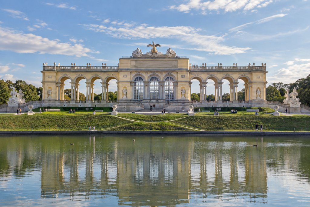 KI-generierte Ansicht der Gloriette mit seitlichen Arkaden und Spiegelung im Wasserbecken.